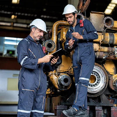 two techs maintain heavy machine uptime